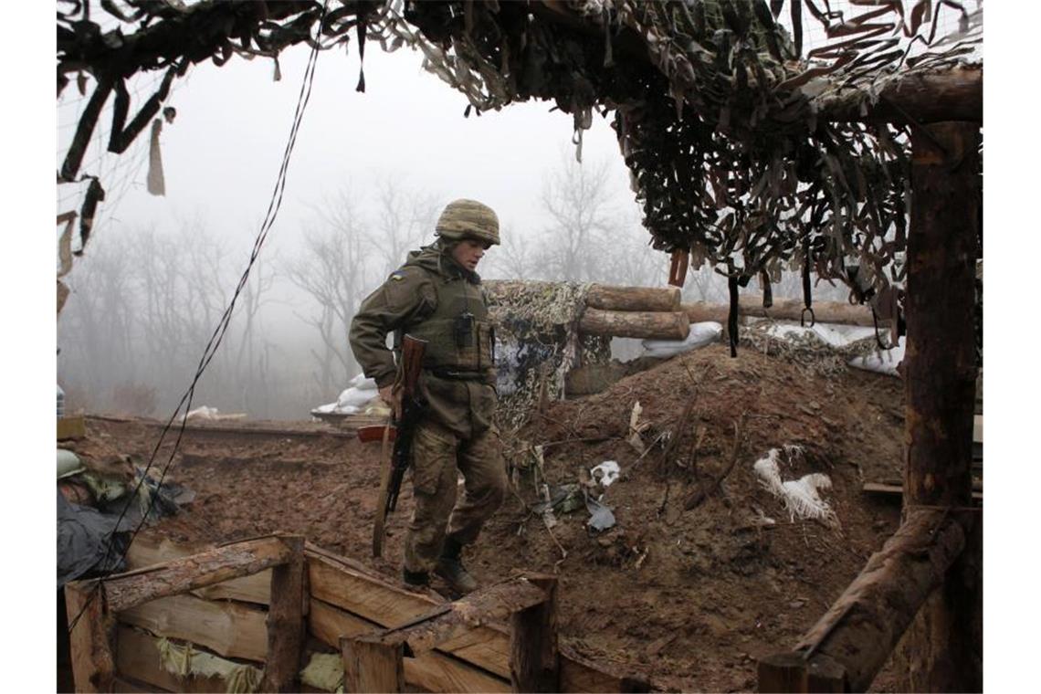 Ukraine-Konflikt: Putin und Selenskyj sprechen über Lösung Ein ukrainischer Soldat bringt sich an der Frontlinie in der Region Donezk in Stellung. Foto: Vitali Komar/AP/dpa