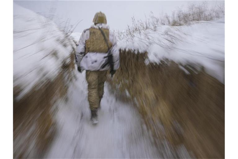 Ein ukrainischer Soldat geht an der Frontlinie durch einen Graben. Foto: Vadim Ghirda/AP/dpa
