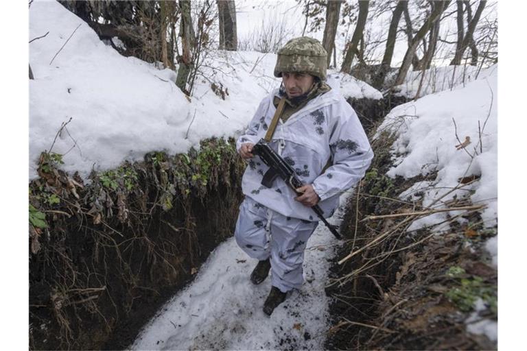 Ein ukrainischer Soldat geht an der Frontlinie zu prorussischen Rebellen in der Region Donezk in einem Schützengraben entlang. Foto: Andriy Dubchak/AP/dpa