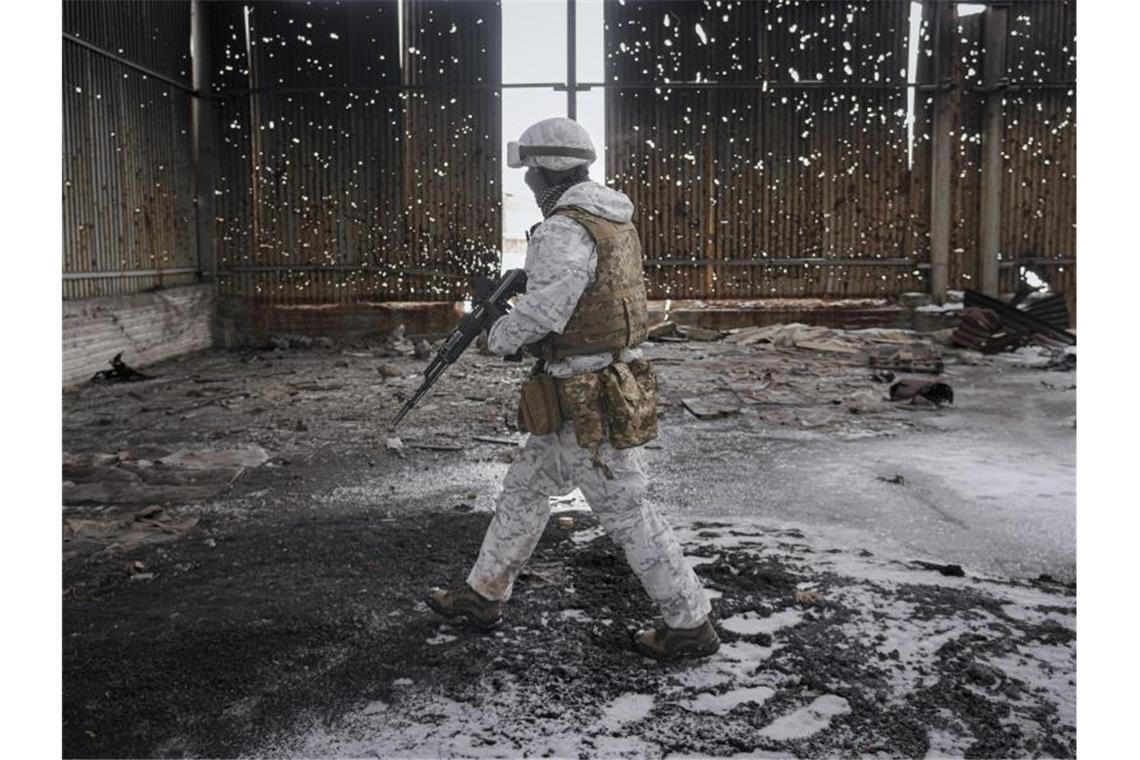 Ein ukrainischer Soldat geht durch eine zerstörte Lagerhalle an der Frontlinie in der Region Donezk. Foto: Vadim Ghirda/AP/dpa