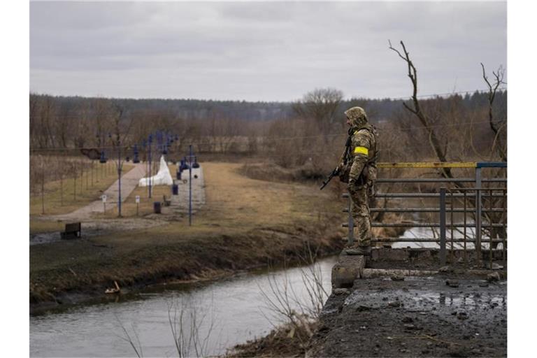Ein ukrainischer Soldat in der Nähe einer zerstörten Brücke am Fluss Irpin. Foto: Emilio Morenatti/AP/dpa/Symbolbild