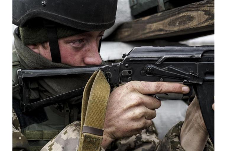 Ein ukrainischer Soldat nimmt seine Position nahe der Frontlinie zu den von Russland unterstützten Separatisten im Südosten des Landes ein. Foto: Evgeniy Maloletka/AP/dpa