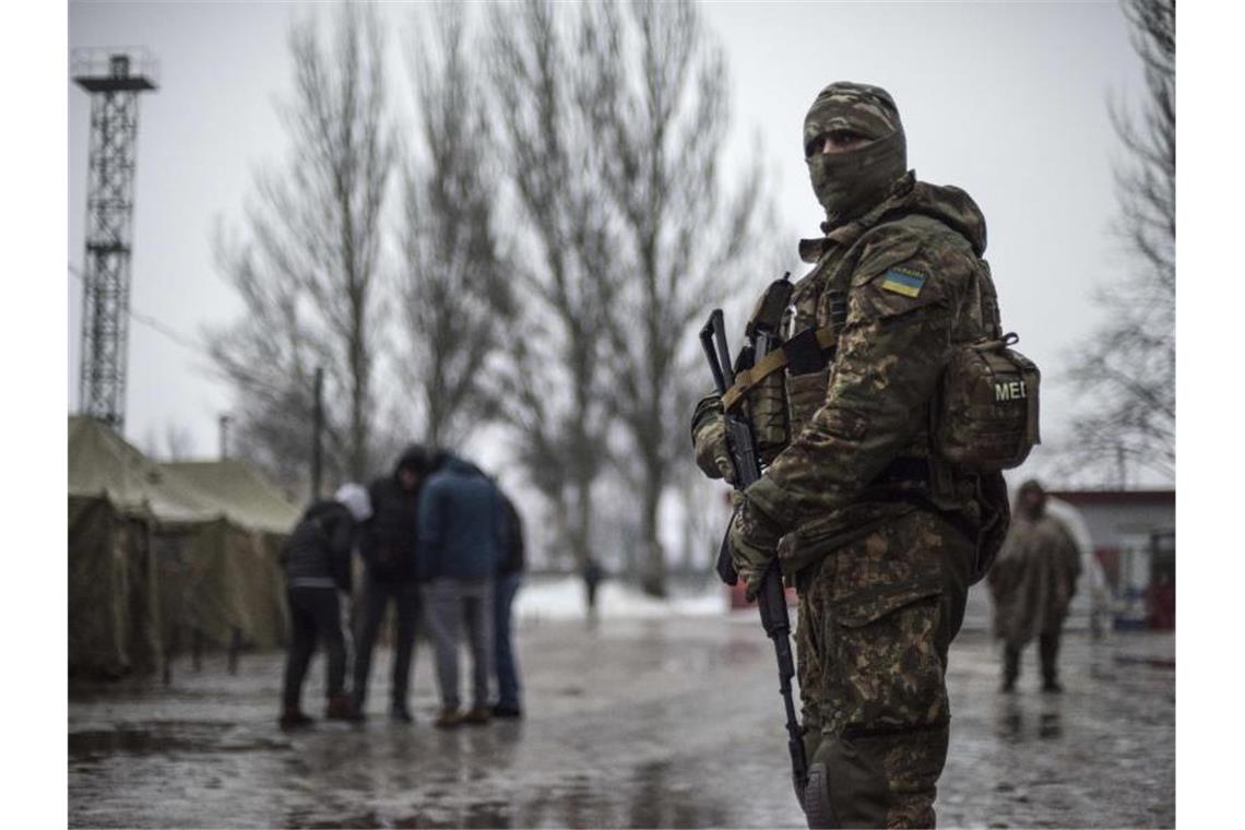 Ein ukrainischer Soldat patrouilliert an einem Stützpunkt für humanitäre Hilfe in der Ostukraine. Für das seit 2014 umkämpfte Gebiet gibt es neue Hoffnungen auf Friedensgespräche. Foto: Evgeniy Maloletka/AP/dpa