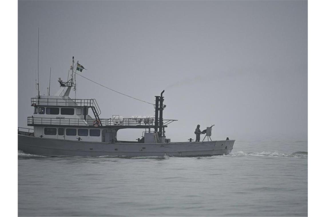 Deutsche Reeder hoffen auf „Ruhe nach dem Sturm“ Ein ukrainischer Soldat steht während einer Patrouille auf dem Asowschen Meer auf einem Militärschiff an einem Maschinengewehr. Foto: Vadim Ghirda/AP/dpa