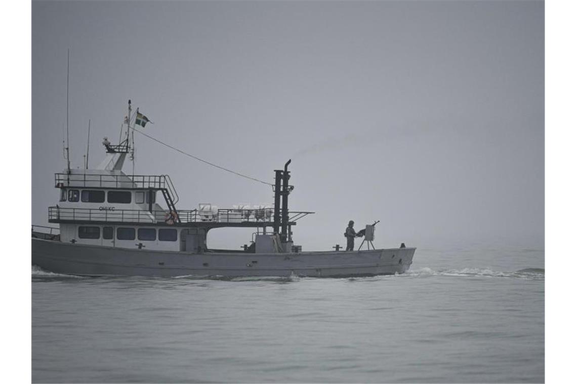 Ein ukrainischer Soldat steht während einer Patrouille auf dem Asowschen Meer auf einem Militärschiff an einem Maschinengewehr. Foto: Vadim Ghirda/AP/dpa