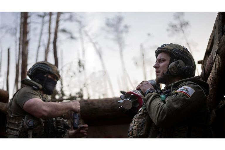 Ein ukrainischer Soldat trägt eine Mörsergranate, während er auf einen Feuerbefehl wartet.