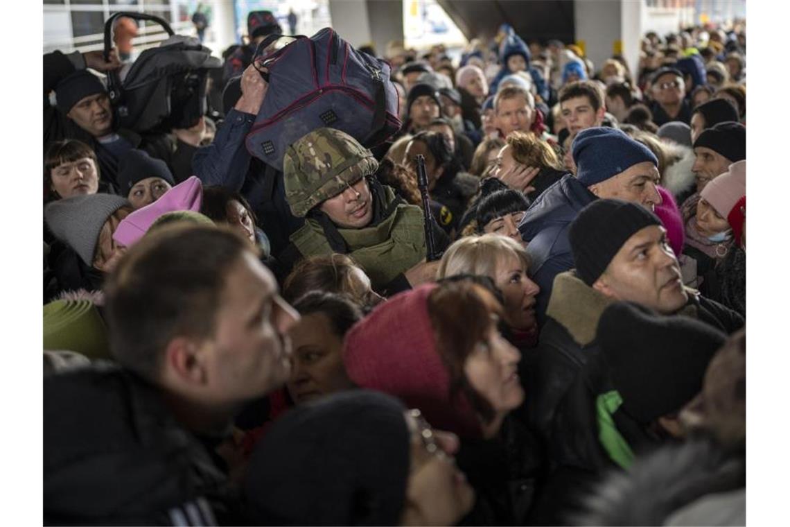 Rund 37.800 ukrainische Flüchtlinge in Deutschland Ein ukrainischer Soldat versucht, die Menschenmenge aufzulösen, die am Bahnhof von Kiew in einen Zug nach Lwiw steigen will. Foto: Emilio Morenatti/AP/dpa