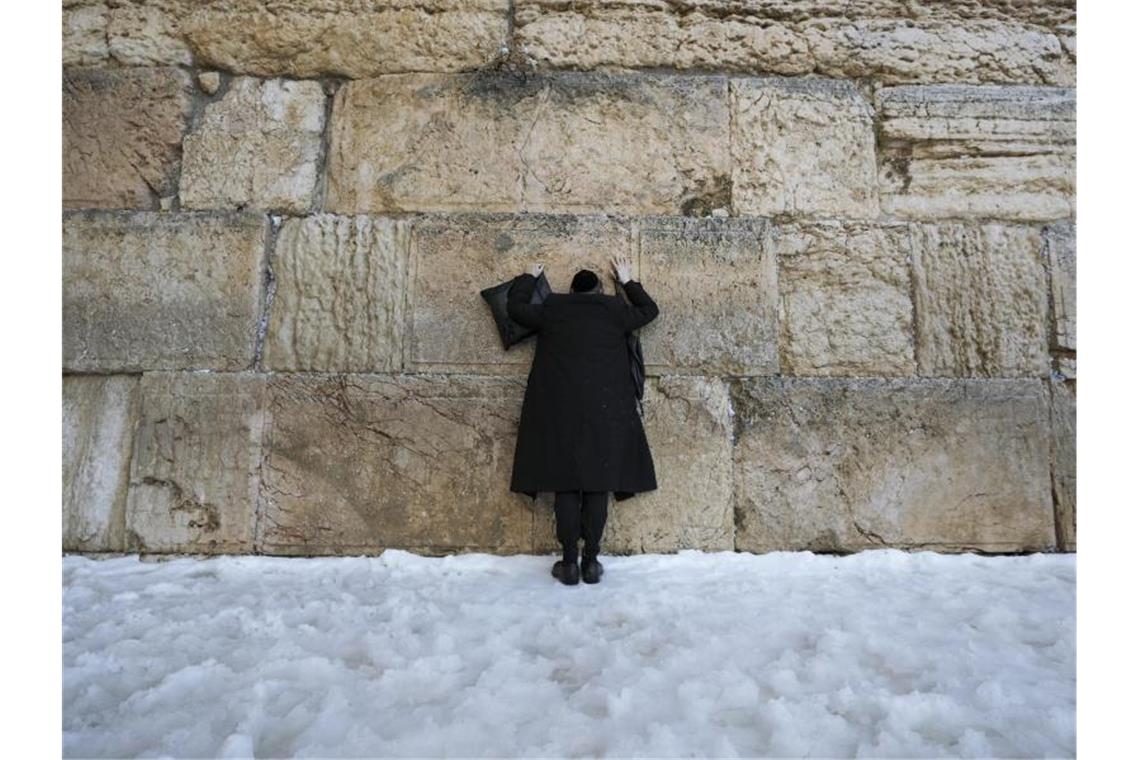 Wintersturm Elpis sorgt für seltenen Schneefall in Jerusalem Ein ultra-orthodoxer jüdischer Mann steht im Schnee an der Klagemauer. Foto: Mahmoud Illean/AP/dpa