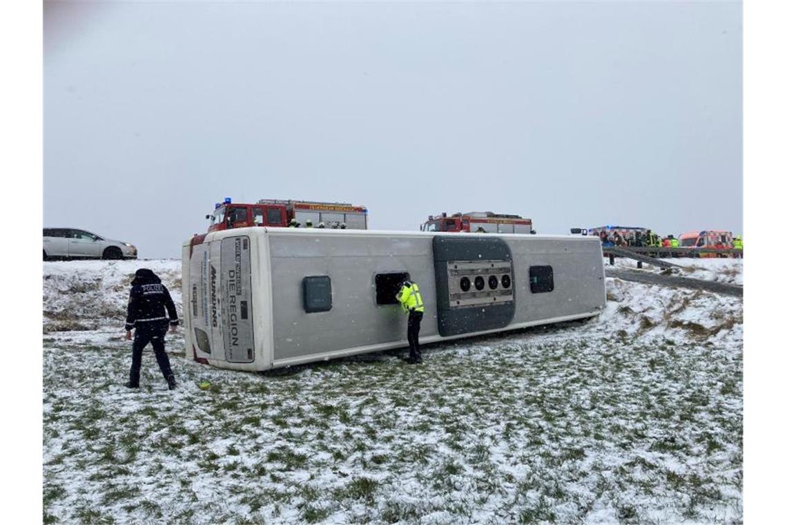 Schulbus von Straße geweht: Bergung hat begonnen Ein umgekippter Schulbus liegt auf einer Wiese neben der Straße. Foto: Gerd Mägerle/Schwäbische Zeitung/dpa