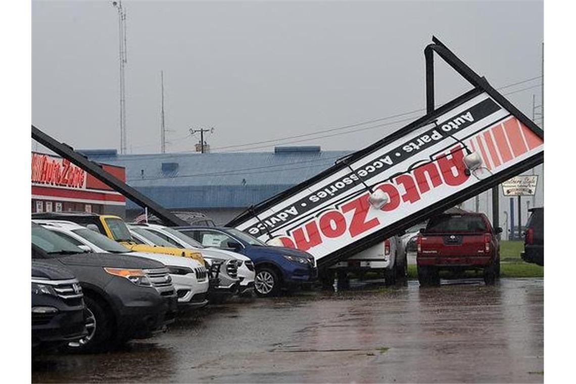 Ein umgestürztes Schild eines Geschäftes liegt auf Autos am Devereux Drive in Natchez, nachdem Hurrikan „Laura“ durchgezogen ist. Foto: Ben Hillyer/The Natchez Democrat/AP/dpa