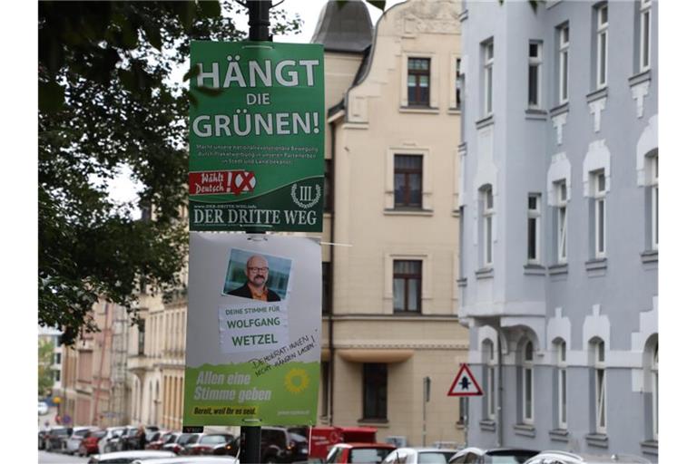 Ein umstrittenes Wahlplakat der Splitterpartei Der Dritte Weg hängt in Zwickau über einem Plakat der Grünen (Archivbild). Foto: Bodo Schackow/dpa-Zentralbild/dpa