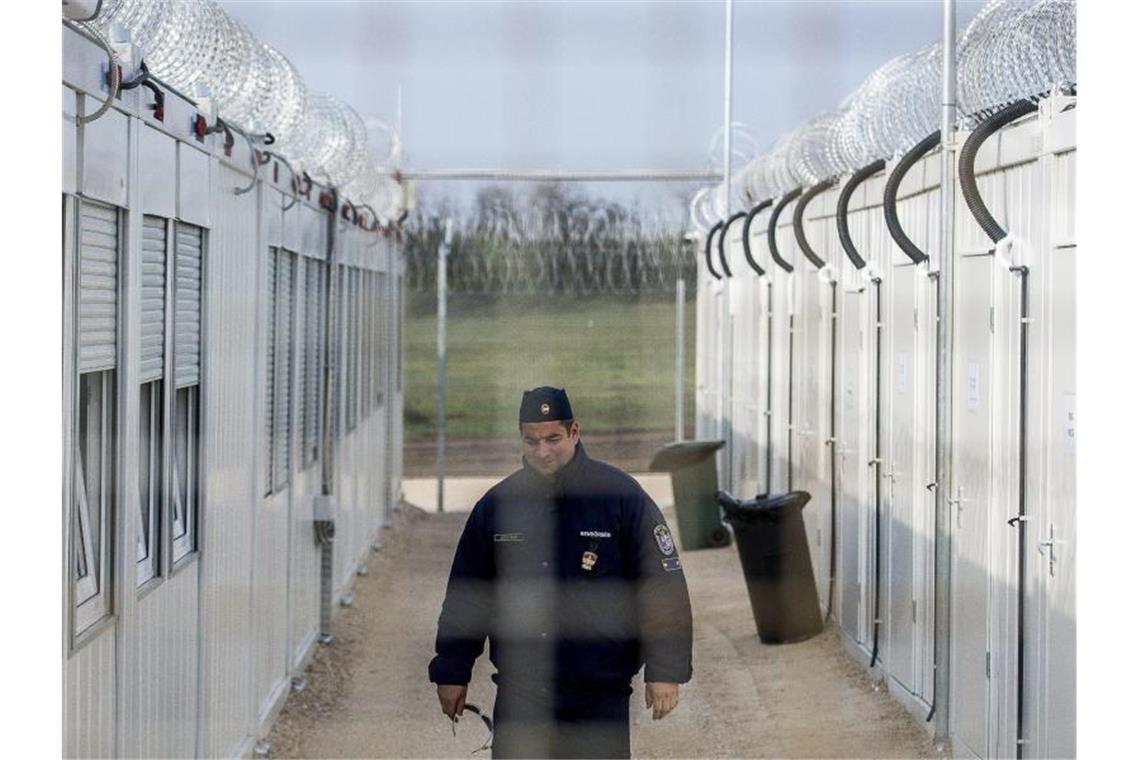 Ein ungarischer Polizist patrouilliert durch ein Lager für Asylsuchende an der Grenze zu Serbien. Foto: Sandor Ujvari/MTI/AP/dpa
