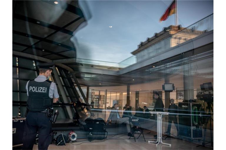 Ein uniformierter Polizist der Bundestags-Polizei beobachtet die Fraktionsebene im Deutschen Bundestag. Nach den Störungen von Bundestagsabgeordneten durch Gäste ist die Bundestagspolizei im Reichstagsgebäude häufiger zu sehen. Foto: Michael Kappeler/dpa