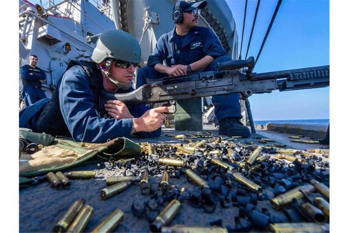 USA erhöhen Druck auf Iran Ein US-Soldat hat während der Ausbildung an Bord des Zerstörers USS Mitscher im Golf von Oman ein M240B Maschinengewehr im Anschlag. US-Präsident Trump schickt im eskalierenden Konflikt mit dem Iran rund 1000 weitere Soldaten in den Nahen Osten. Foto: Jacob Milham/US Navy
