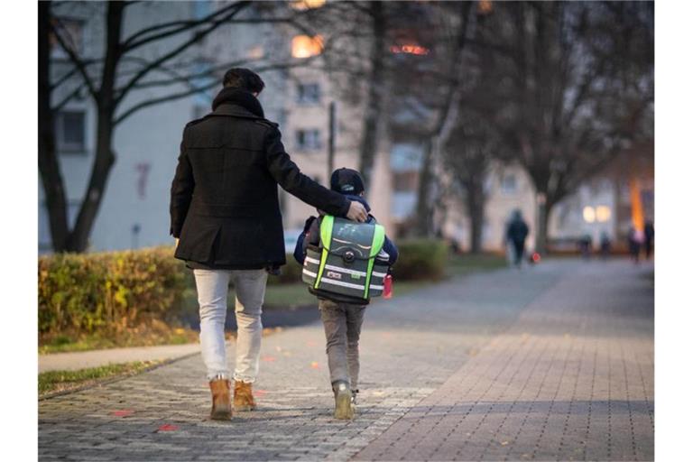 Ein Vater begleitet seinen Sohn auf dem Schulweg. Foto: Frank Rumpenhorst/dpa/Symbolbild