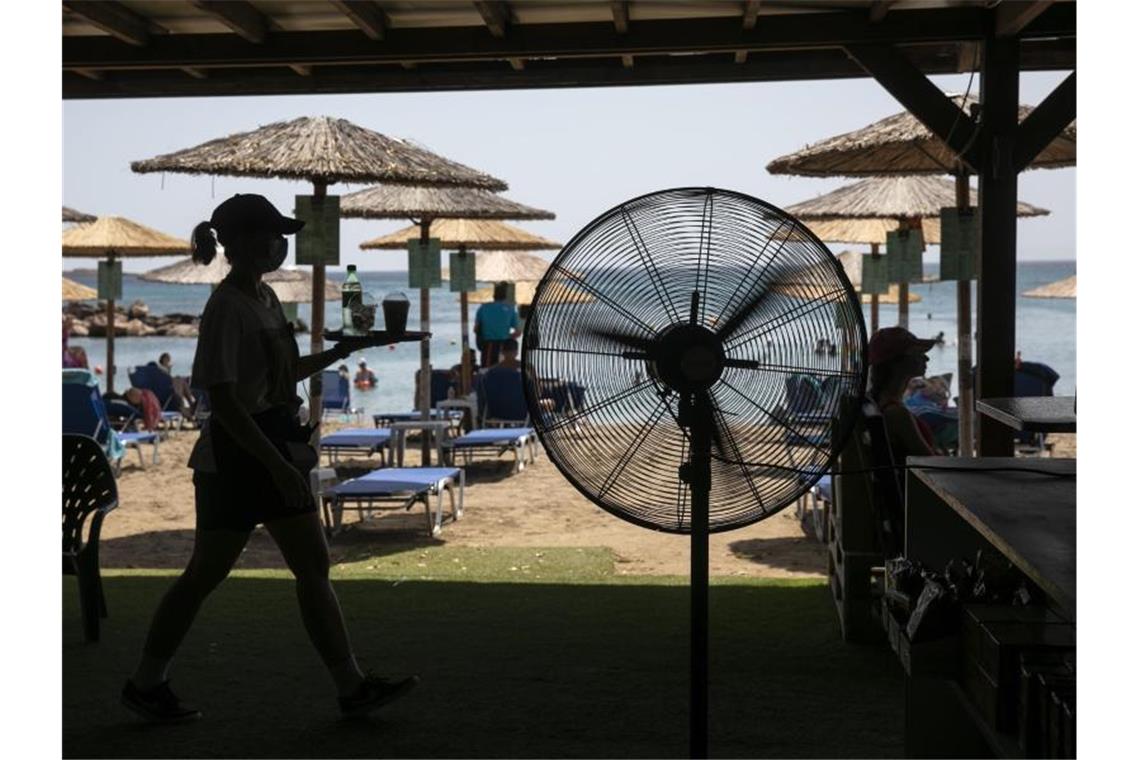 Hunderte Waldbrandeinsätze auf Sizilien - Hitze in Südeuropa Ein Ventilator sorgt in Lagonissi unweit von Athen für ein bisschen Abkühlung. Foto: Yorgos Karahalis/AP/dpa
