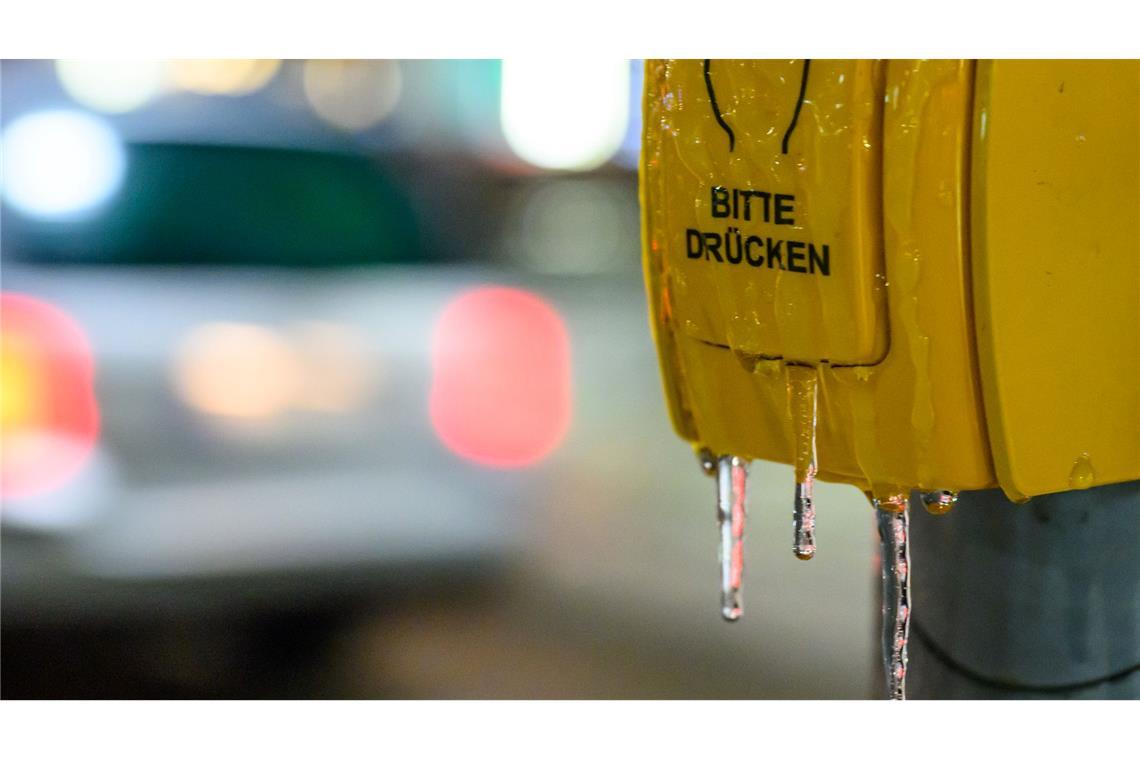 Ein vereister Tastschalter ist an einer Haltestelle in Brandenburg am frühen Morgen zu sehen.