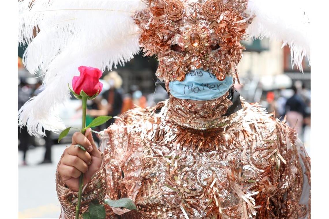 Ein verkleideter Demonstrant hält bei einem „Black Lives Matter“-Protest in New Yorks Stadtteil Harlem eine Rose in der Hand. Foto: Vanessa Carvalho/ZUMA Wire/dpa