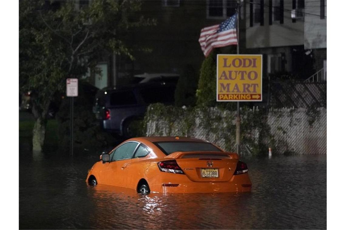 Mehrere Tote nach Extremwetter und Land unter in New York Ein verlassenes Auto steht im Hochwasser auf einer Straße in New Jersey. Foto: Seth Wenig/AP/dpa