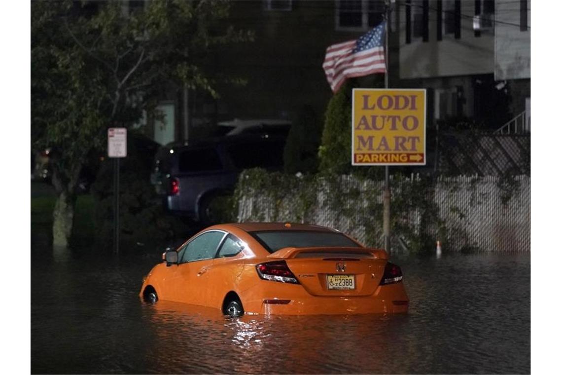 Ein verlassenes Auto steht im Hochwasser auf einer Straße in New Jersey. Foto: Seth Wenig/AP/dpa