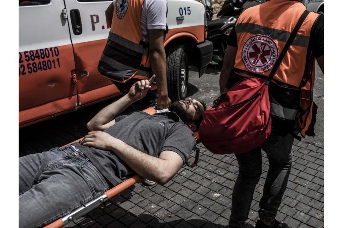 Ein verletzter palästinensischer Demonstrant wird von Sanitätern weggebracht. Foto: Ilia Yefimovich/dpa