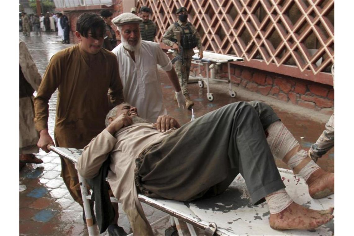 Ein verwundeter Mann wird mit einer Trage in ein Krankenhaus gebracht. Foto: Wali Sabawoon/AP/dpa