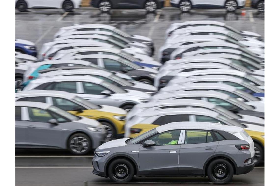 Ein Volkswagen ID.4 fährt zur Auslieferung über einen Zwickauer Parkplatz mit weiteren Neuwagen. Foto: Jan Woitas/dpa-Zentralbild/dpa