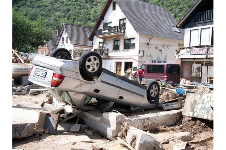 Ein von der Flut mitgerissenes Auto liegt in der Stadtmitte von Altenahr. Zahlreiche Häuser in dem Ort wurden komplett zerstört oder stark beschädigt. Foto: Boris Roessler/dpa