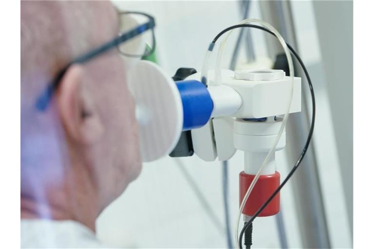 Ein von einer Corona-Erkrankung genesener Patient bekommt in einer Lungentest-Kabine in einer Rehaklinik die Lungenfunktion gemessen. (Archivbild). Foto: Uwe Anspach/dpa