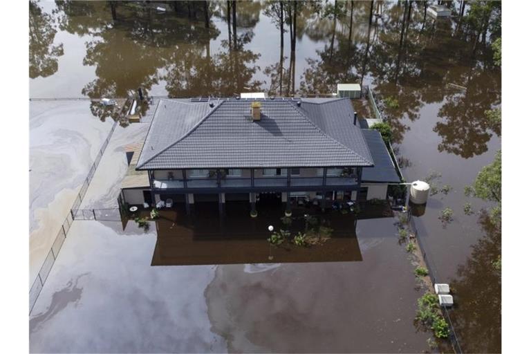Ein von Wasser umgebenes Haus am Stadtrand von Sydney. Im Frühjahr hatte die Ostküste Australiens unter Rekordregen zu leiden. Foto: Mark Baker/AP/dpa