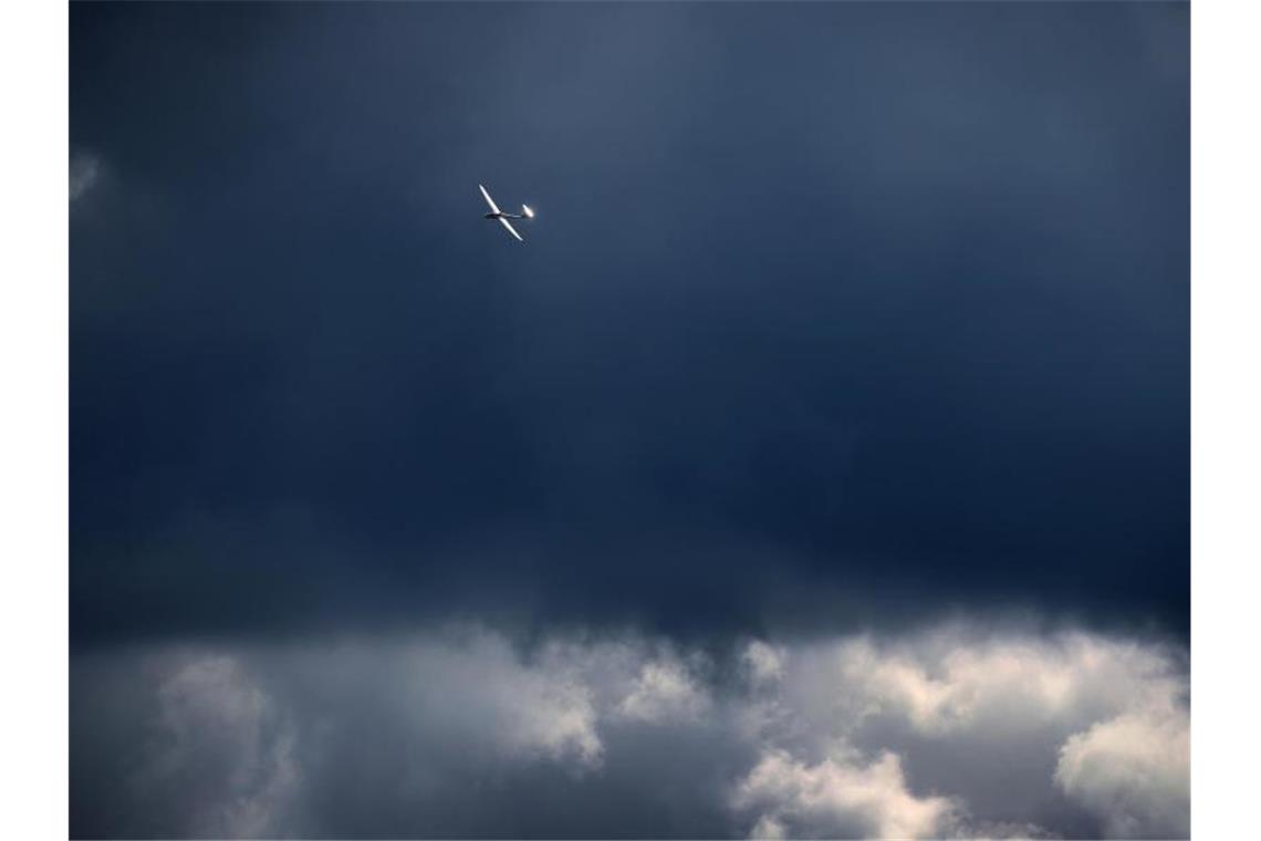Ein vor den Wolken fliegendes Segelflugzeug wird von der Sonne beschienen. Foto: Karl-Josef Hildenbrand/dpa/Symbolbild