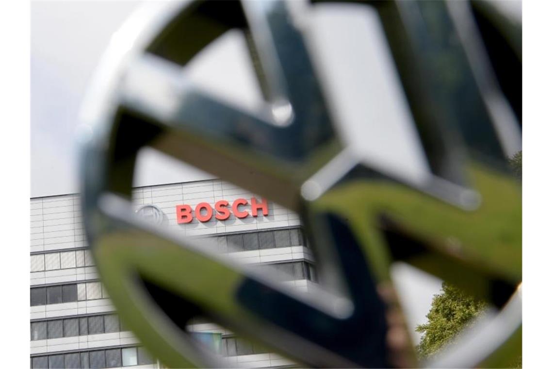 VW und Bosch: Projekt könnte Gemeinschaftsfirma vorbereiten Ein VW Logo wird vor den Bosch Stammsitz gehalten. Foto: picture alliance / Franziska Kraufmann/dpa/Illustration