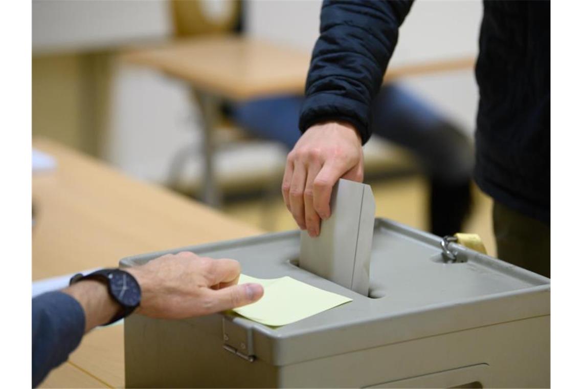 Viele Briefwähler: Beteiligung in Wahllokalen sinkt Ein Wähler wirft im Wahllokal seinen Stimmzettel in eine Wahlurne. Foto: Robert Michael/dpa-Zentralbild/dpa