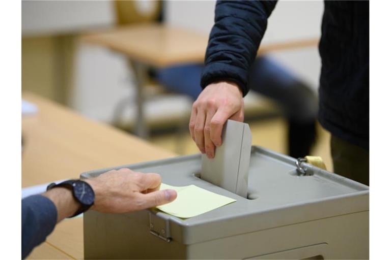 Ein Wähler wirft im Wahllokal seinen Stimmzettel in eine Wahlurne. Foto: Robert Michael/dpa-Zentralbild/dpa