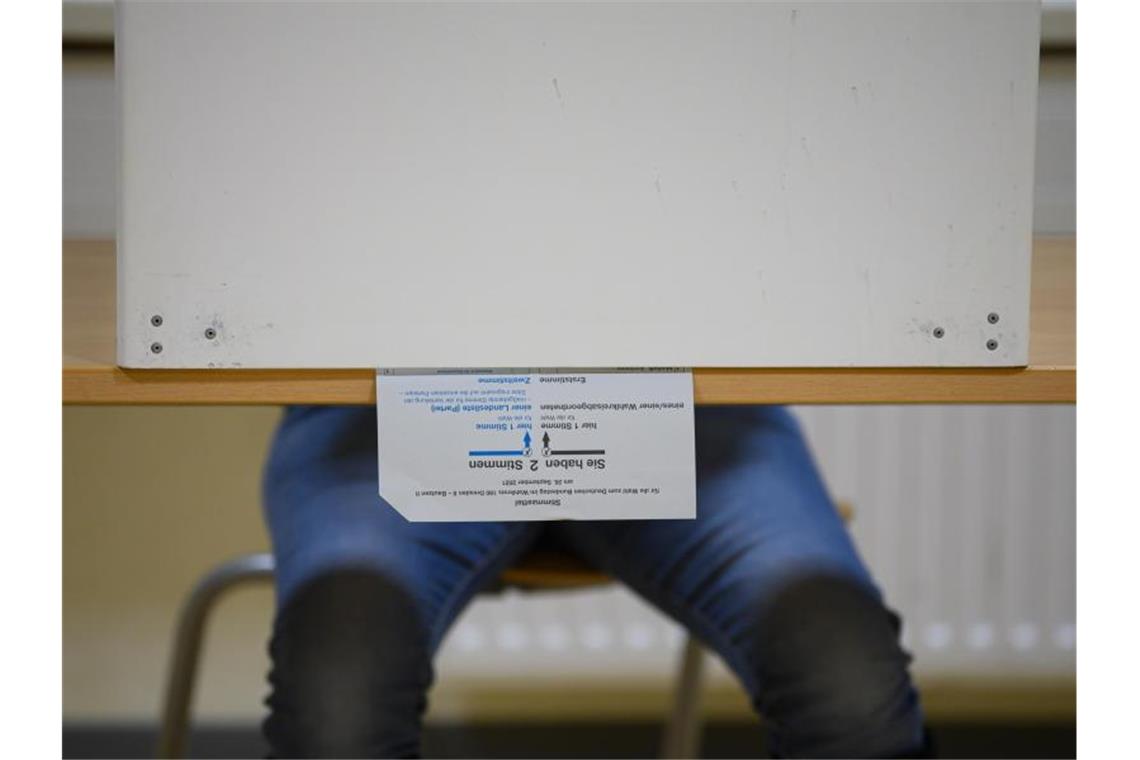 SPD gewinnt Bundestagswahl vor Union Ein Wählerin sitzt in Dresden bei der Stimmabgabe zur Bundestagswahl mit ihrem Stimmzettel in der Wahlkabine. Knapp 60,4 Millionen Deutsche sind aufgerufen, den neuen Bundestag zu wählen. Foto: Robert Michael/dpa-Zentralbild/dpa