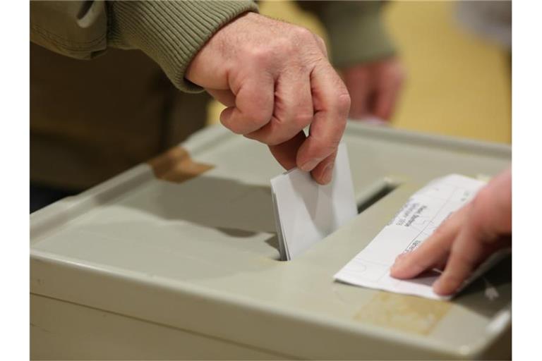 Ein Wahlberechtigter steckt seinen Stimmzettel in die Wahlurne in einem Wahlbüro. Foto: Matthias Bein/dpa-Zentralbild/dpa