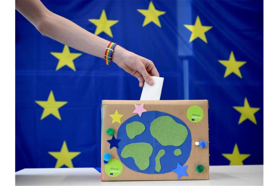 Ein Wahlzettel wird in eine selbstgebastelte Wahlurne in einem Wahllokal bei der U18-Europawahl eingeworfen. Foto: Britta Pedersen/Archivbild