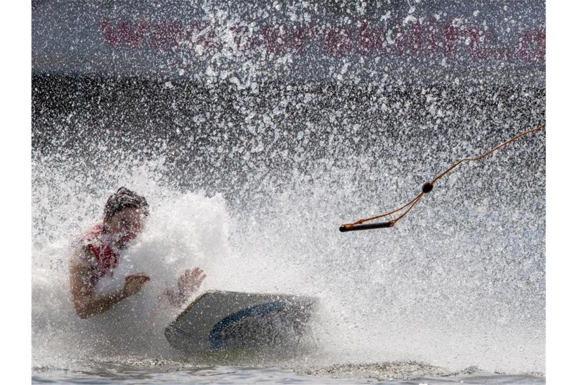 Knüppelheiß: Neue Hitzerekorde halten Deutschland in Atem Ein Wakeboardfahrer stürzt bei einer Runde auf der Wasserskianlage sicher nicht ganz ungern ins erfrischende Wasser. Foto: Jens Büttner