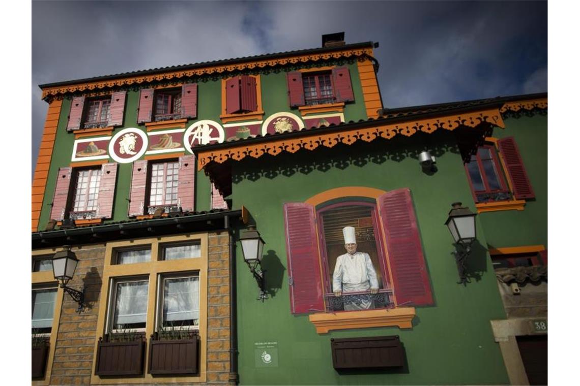Ein Wandgemälde von Paul Bocuse schmückt die Fassade des Gourmet-Restaurants „L'Auberge du Pont de Collonges“. Foto: Ian Langsdon/epa/dpa