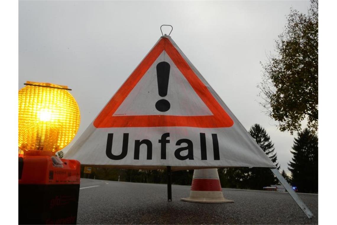 Ein Warndreieck mit der Aufschrift „Unfall“ steht auf der Straße. Foto: Patrick Seeger/Archivbild