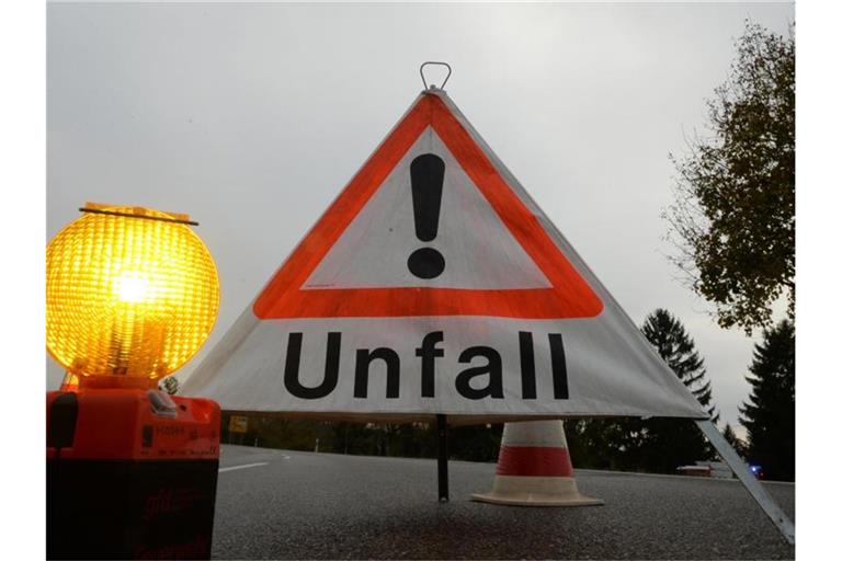 Ein Warndreieck mit der Aufschrift „Unfall“ steht auf der Straße. Foto: Patrick Seeger/dpa/Archivbild