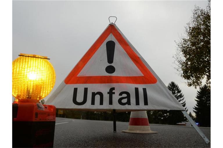 Ein Warndreieck mit der Aufschrift „Unfall“ steht auf der Straße. Foto: Patrick Seeger/Archivbild