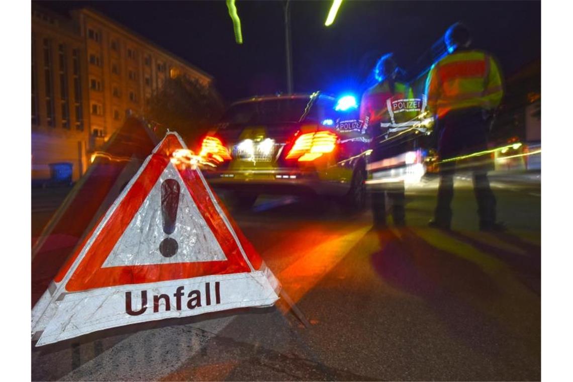 Ein Warndreieck steht neben einem Polizeifahrzeug auf der Straße. Foto: Patrick Seeger/dpa/Symbolbild