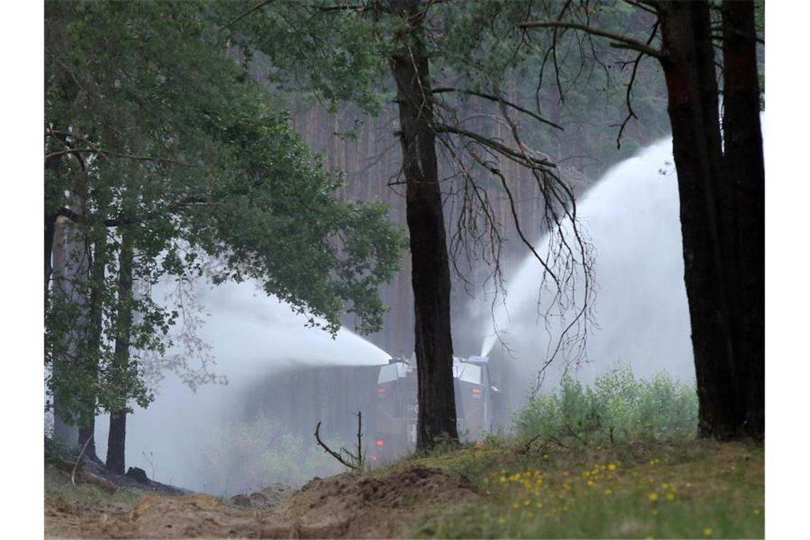 Ein Wasserwerfer der Bundespolizei spritzt Löschwasser in der Nähe der Ortschaft Alt Jabel auf Glutnester in einem abgebrannte Waldstück. Foto: Bodo Marks