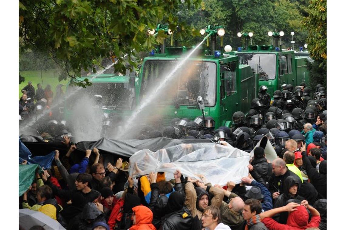 Ein Wasserwerfer spritzt im Schlossgarten Stuttgart auf Demonstranten. Foto: picture alliance/dpa/Archivbild