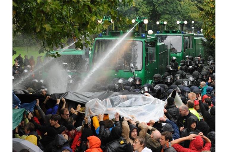 Ein Wasserwerfer spritzt im Schlossgarten Stuttgart auf Demonstranten. Foto: picture alliance/dpa/Archivbild