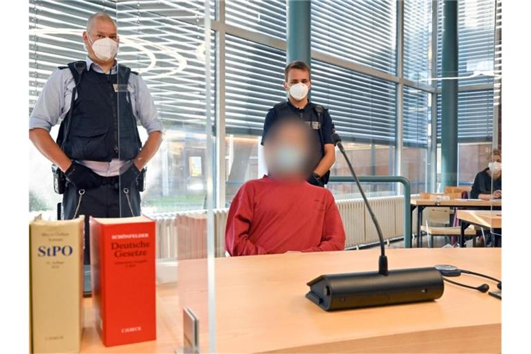 Ein wegen Mordes Angeklagter sitzt auf der Anklagebank im Gerichtssaal. Foto: Felix Kästle/dpa