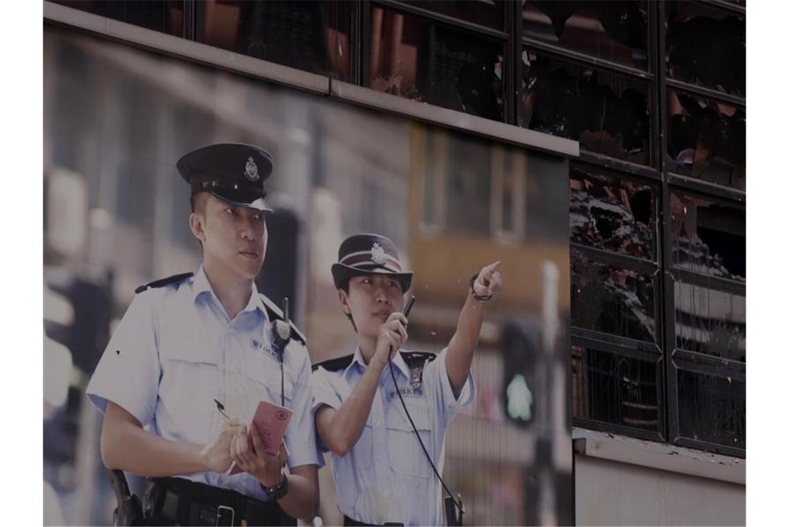 Ein Werbeplakat der Polizei hängt vor einer zerstörten Polizeistation. Foto: Liau Chung-Ren/ZUMA Wire