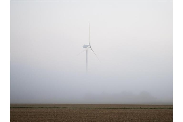 Ein Windrad ragt bei Hannover aus dem morgendlichen Nebel. Foto: Julian Stratenschulte/dpa