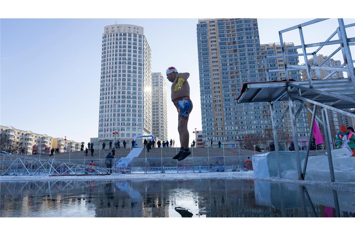 Ein Winterschwimmer springt in Harbin in der chinesischen Provinz Heilongjiang ins eiskalte Wasser.